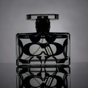 Artistic black and white shot of a designer perfume bottle with reflection.